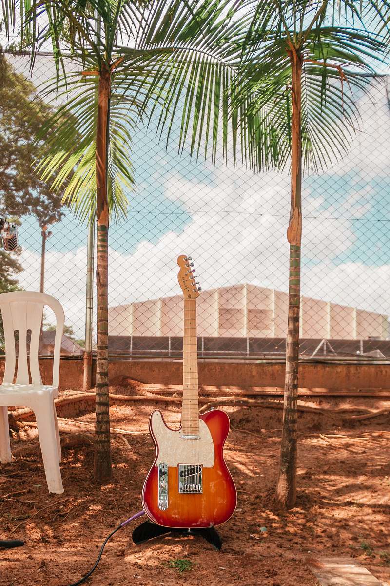electric guitar brown and white electric guitar near monobloc chair and trees during daytime guitar